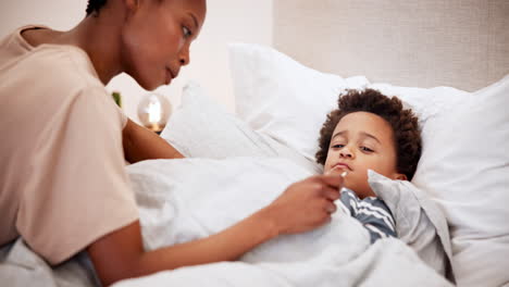 woman, thermometer and sick child in bed