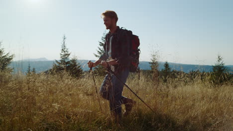 smiling guy hiking on grassy field