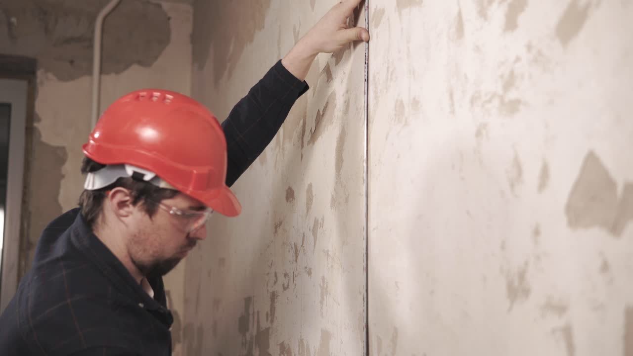 Construction worker measuring wall