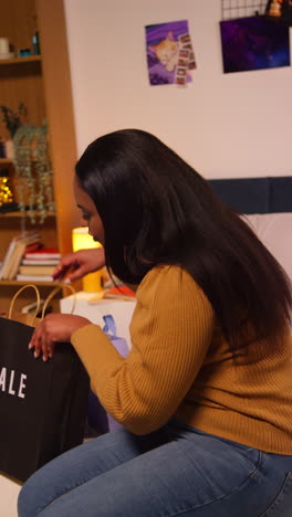 woman unboxing a pink shopping bag