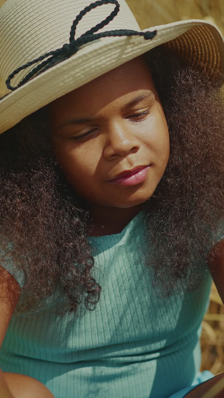 Young Girl in a Straw Hat in a Wheat Field