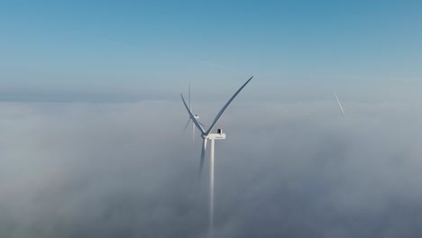 wind turbines shrouded by clouds in skive, denmark