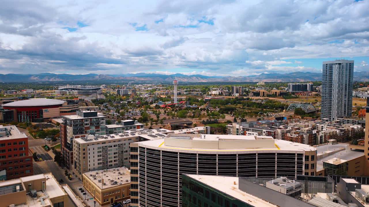 Denver, USA, 24 August 2025: Slowly rising over the urban landscape of Denver, Colorado, USA. Fluffy clouds cover the sky over the cityscape. Mountains at backdrop