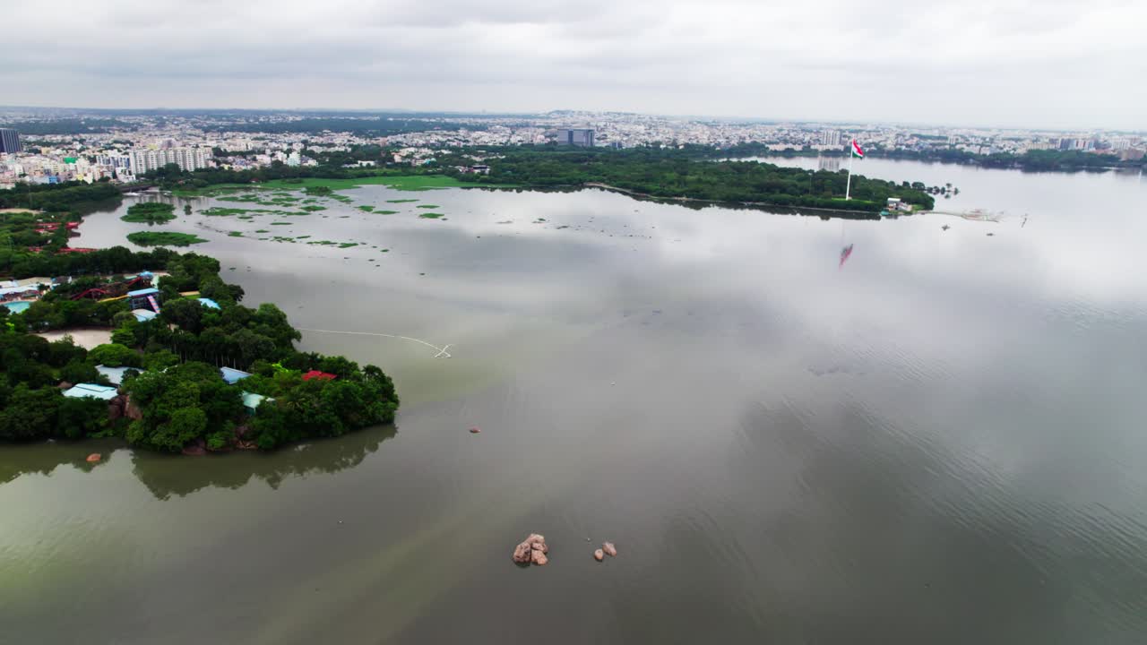 Aerial view of hussain sagar lake with Sanjeevaiah Park and hyderabad cityscape. day time, parallax shot, drone shot, 4k
