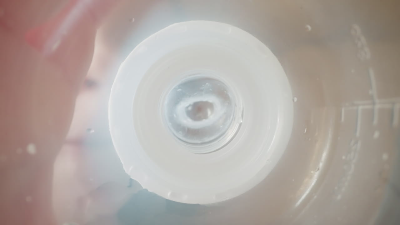 귀여운 소년은 비어있는 병을 들고  ⁇   ⁇ 꺼기를 빨고 있습니다.