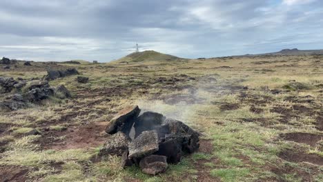 Sulfuric-steam-rising-from-the-ground-between-rocks-near-Grundavik,-Iceland