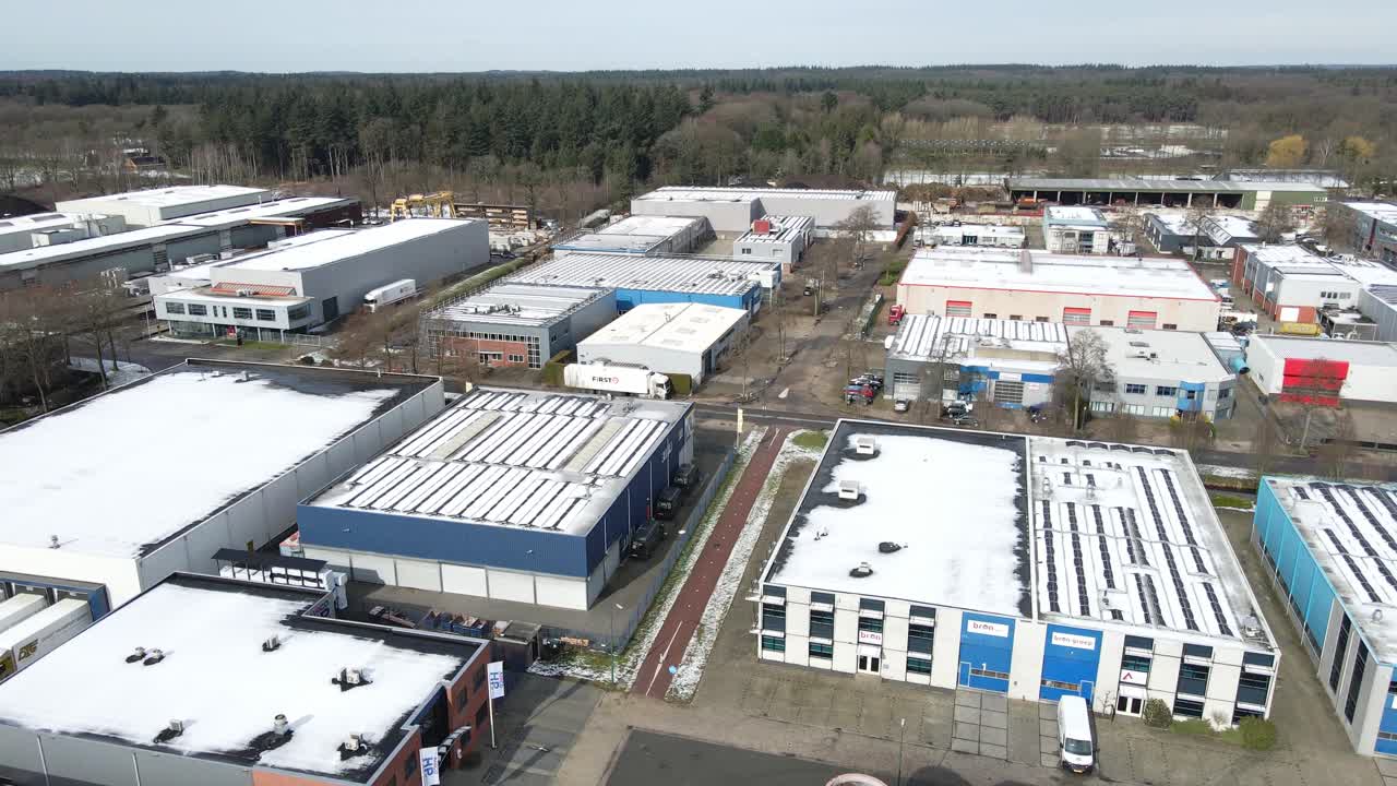 vista aérea de un gran sitio industrial con techos cubiertos de nieve y caminos limpios