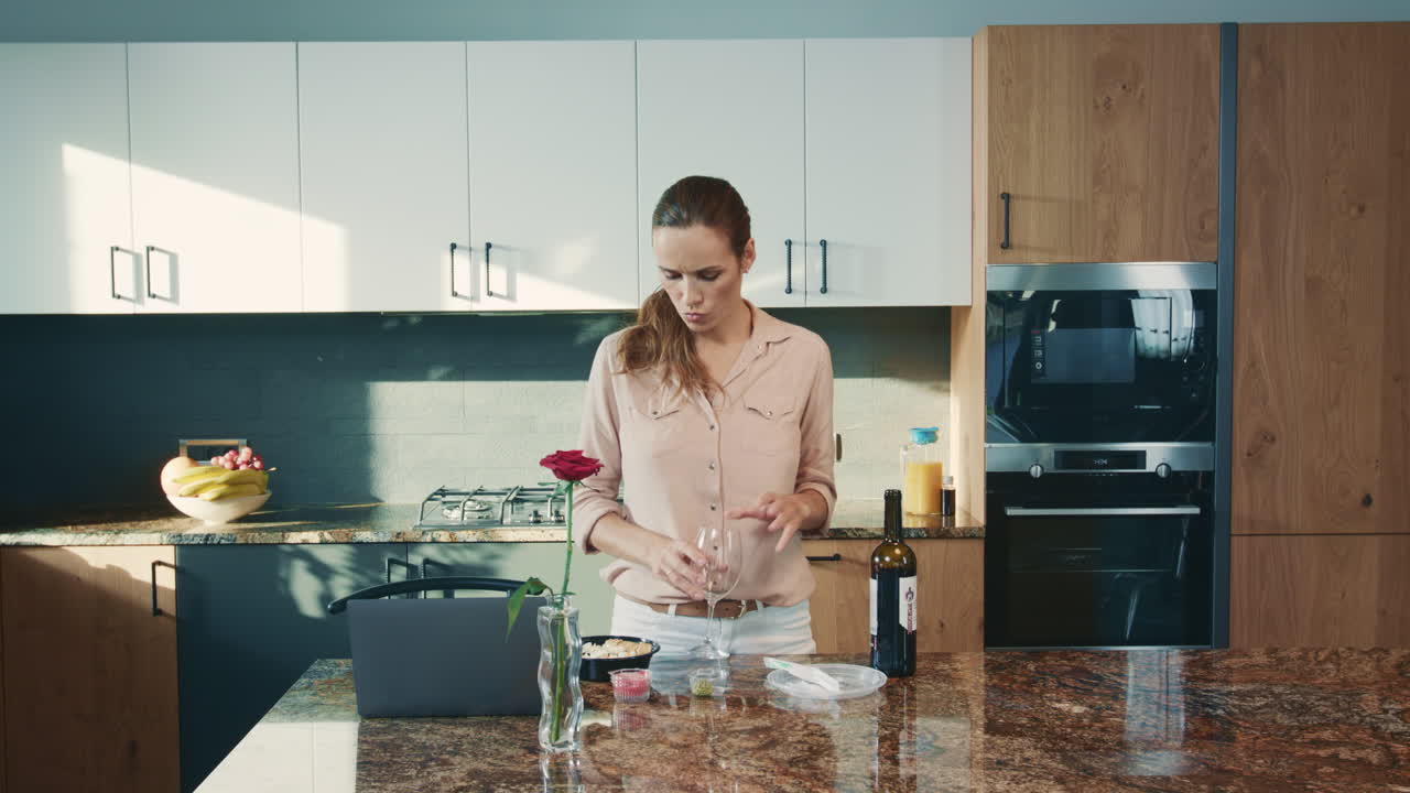 Bella donna che beve vino in cucina. Donna d'affari che lavora con un bicchiere di vino rosso.
