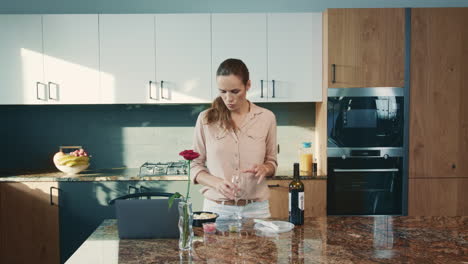 mujer hermosa bebiendo vino en la cocina. mujer de negocios trabajando con vino tinto.