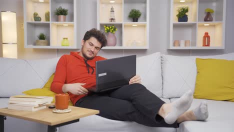 hombre viendo una película en su computadora portátil con expresión feliz.