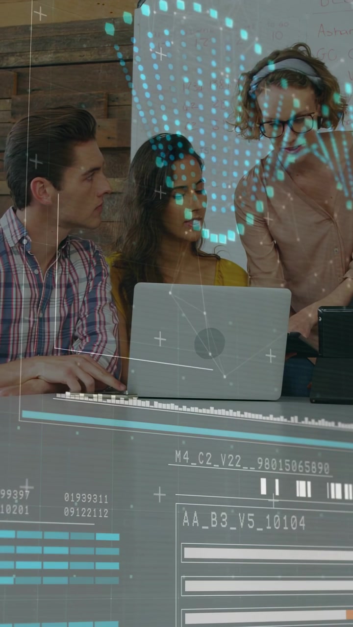 Vídeo vertical: Líder apontando para o laptop enquanto a equipe digita, HUD exibindo gráficos para revisão tecnológica.