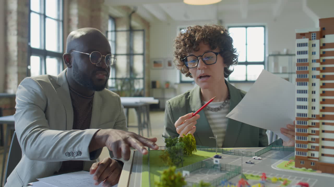 Architects Discussing Building Model and Blueprints for Urban Development