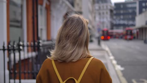 Cinematic-dramatic-video-of-a-mysterious-woman-turning-her-back-on-the-camera-and-walking-away-in-a-London-street-in-slow-motion