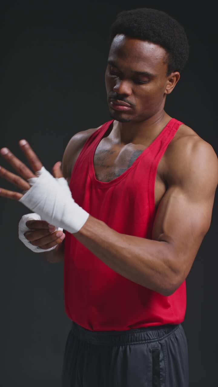 Video verticale di un pugile che si fascia le mani con bende protettive prima di un incontro di boxe o di una sessione di allenamento 4
