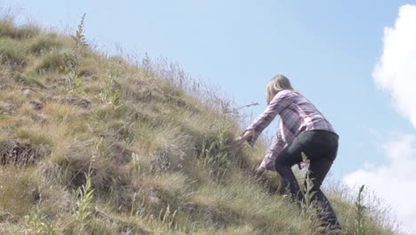 woman climbing hill in rugged moorland