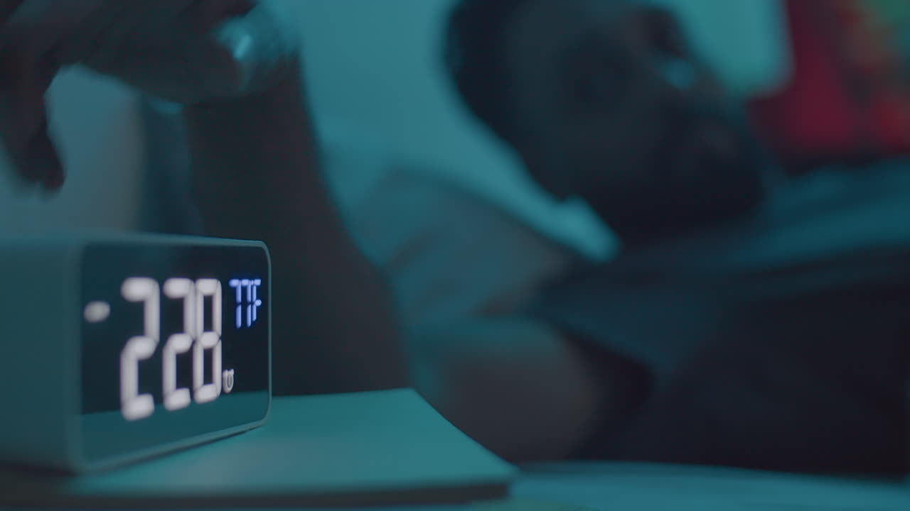 Sleepless Man Suffering from Insomnia Lying in Bed at Night