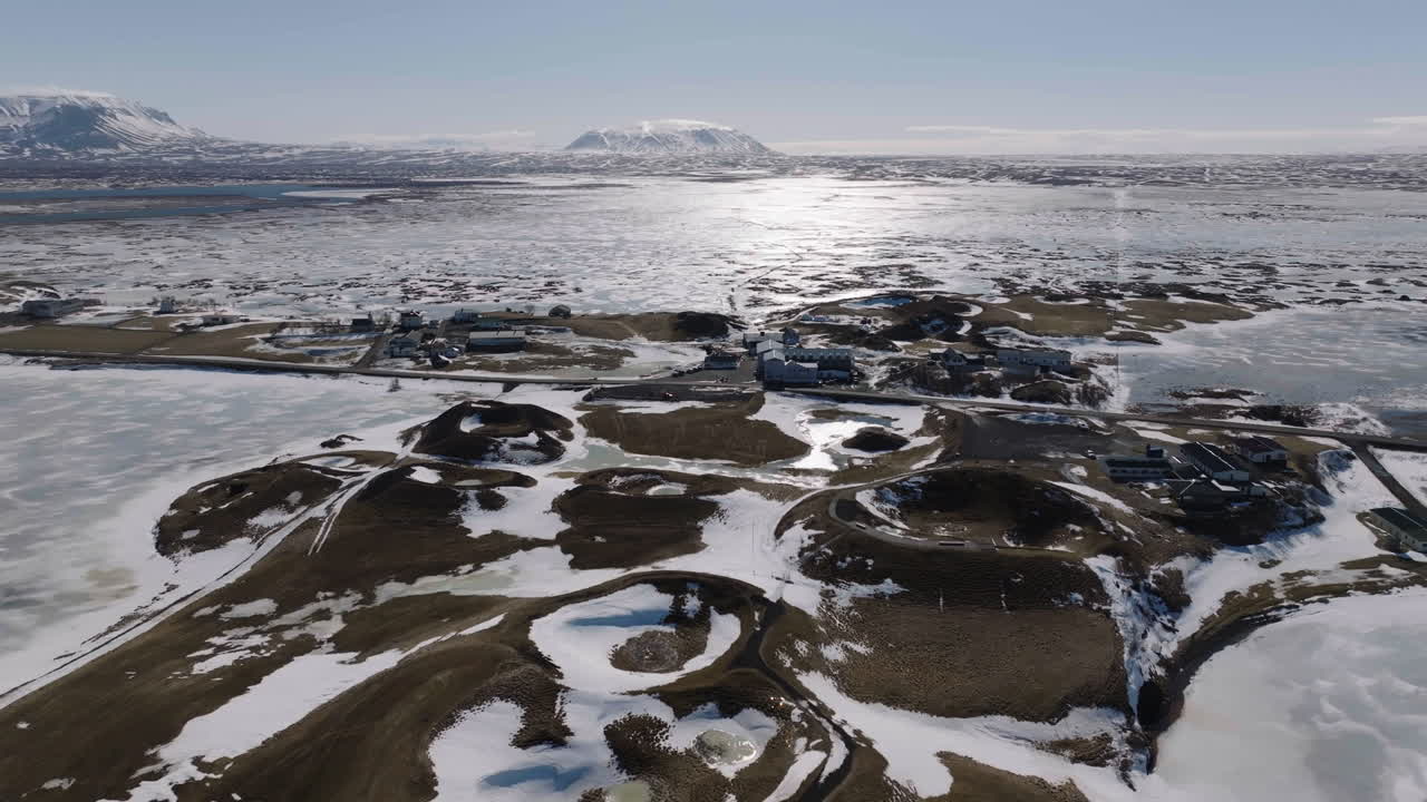 воздушный вид на идиллический зимний пейзаж исландии в солнечный зимний день, замороженное озеро и вулканические ящики