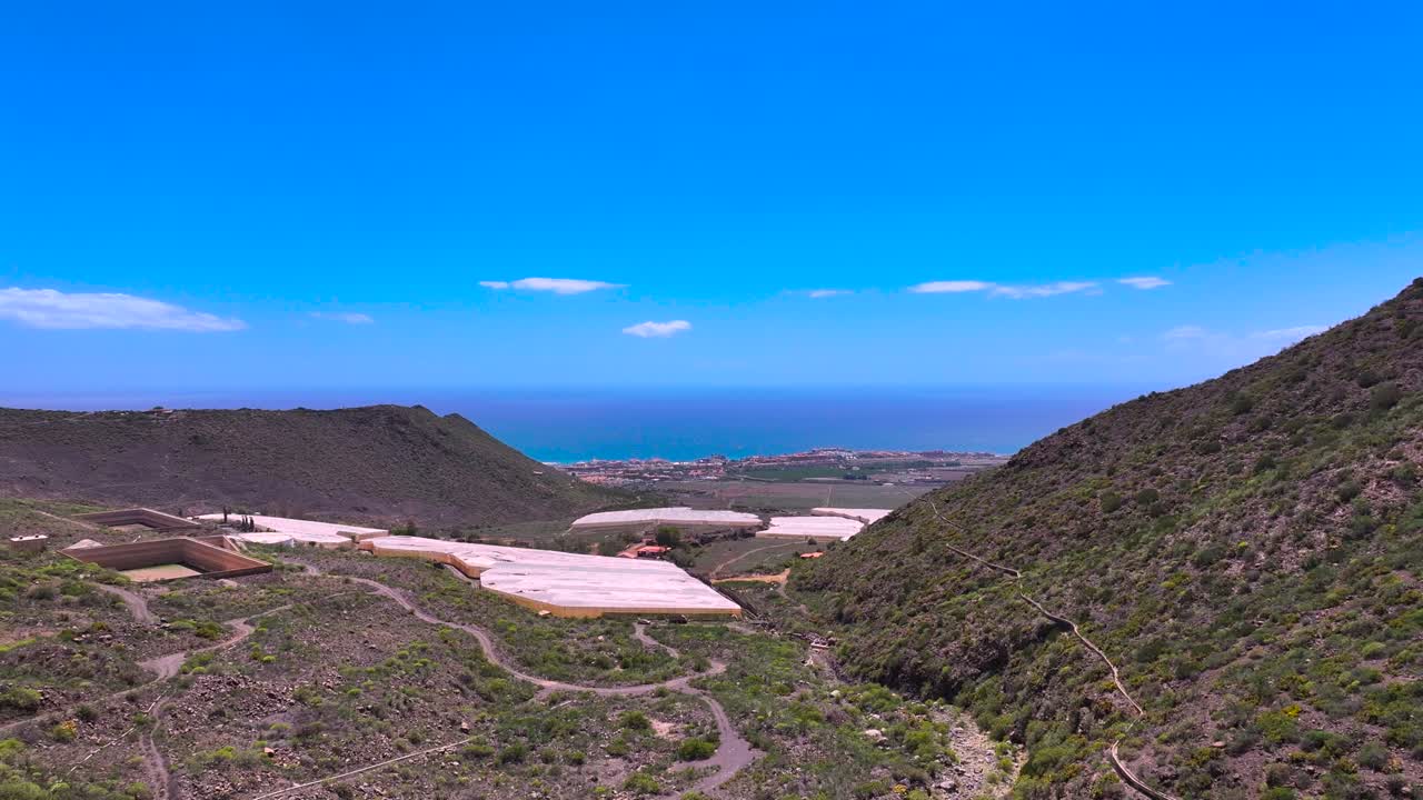 View of Costa Adeje with banana plantations and ocean in Tenerife's hilly terrain