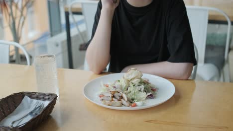 girl eating salad in cafe