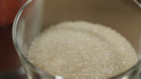 primer plano de un frasco de vidrio con azúcar blanco refinado