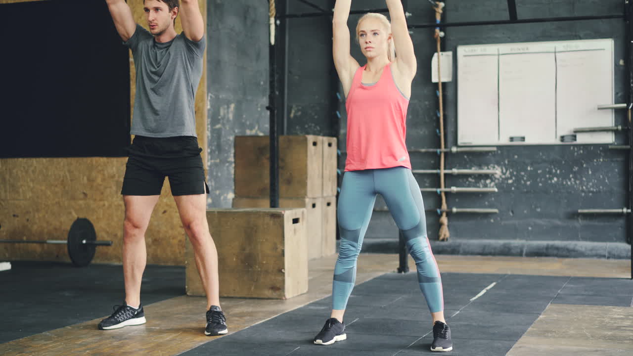 Couple working out with kettlebells in a gym