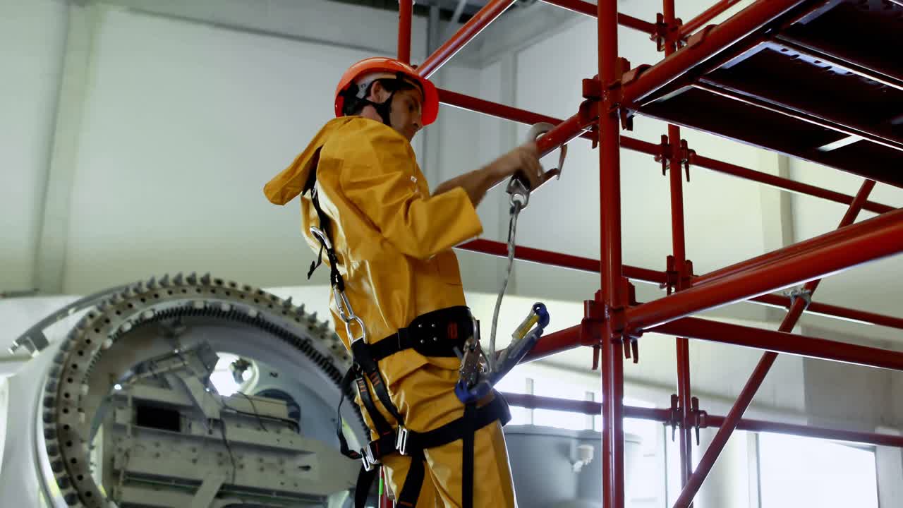 Operaio che scende dall'impalcatura presso impianto solare 4k