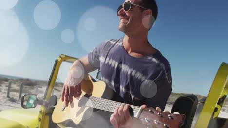 Animation-of-dots-over-happy-caucasian-man-with-guitar-on-beach