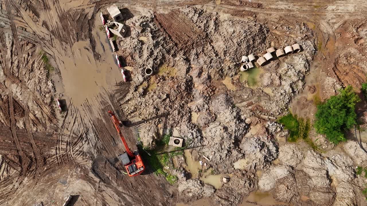 Construction Site with Excavator and Concrete Pipes