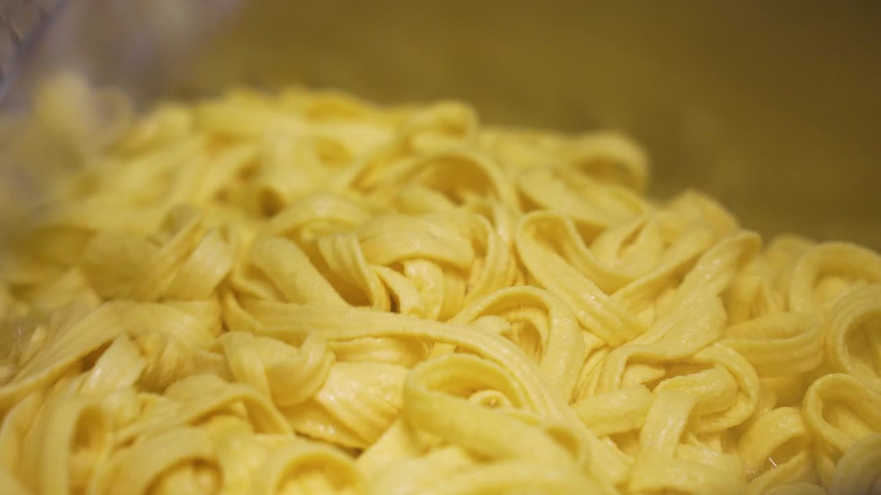 agitando los fideos de spaetzle en una olla grande
