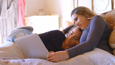 lesbian couple using laptop in bedroom 4k