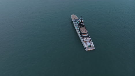 private super yacht anchored in hong kong, sunset, aerial cinematic establishing wide angle