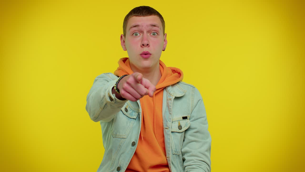 잘생긴 성인 남자가 카메라를 가리키며 장난스러운 행복한 표정으로 선택을 하고 있습니다.