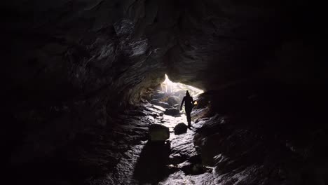 estática, persona caminando hacia la salida de la cueva de luxmore, kepler track nueva zelanda