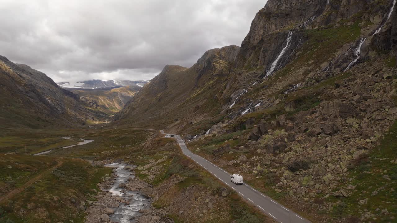 Scenic view of a winding road through Norwegian mountains with waterfalls