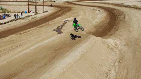 El-Piloto-De-Acrobacias-En-Motocicleta-Se-Eleva-En-Un-Salto-De-Tierra---Vista-Aérea-En-Cámara-Lenta