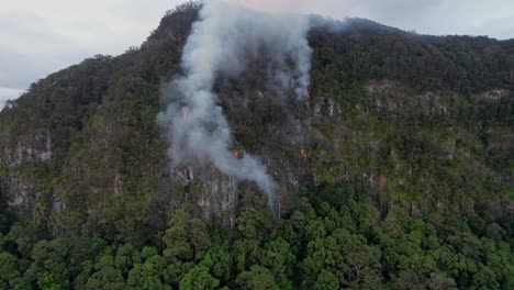 smoke from wildfire destroying mountain forest in queensland, australia