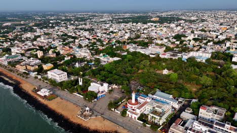 aerial views of puducherry's entire coast and the city. a long pier stretches into the sea alongside the city's distinct buildings and the promenade