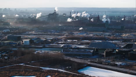 Industrial-complex-with-smokestacks,-early-morning-light,-aerial-view