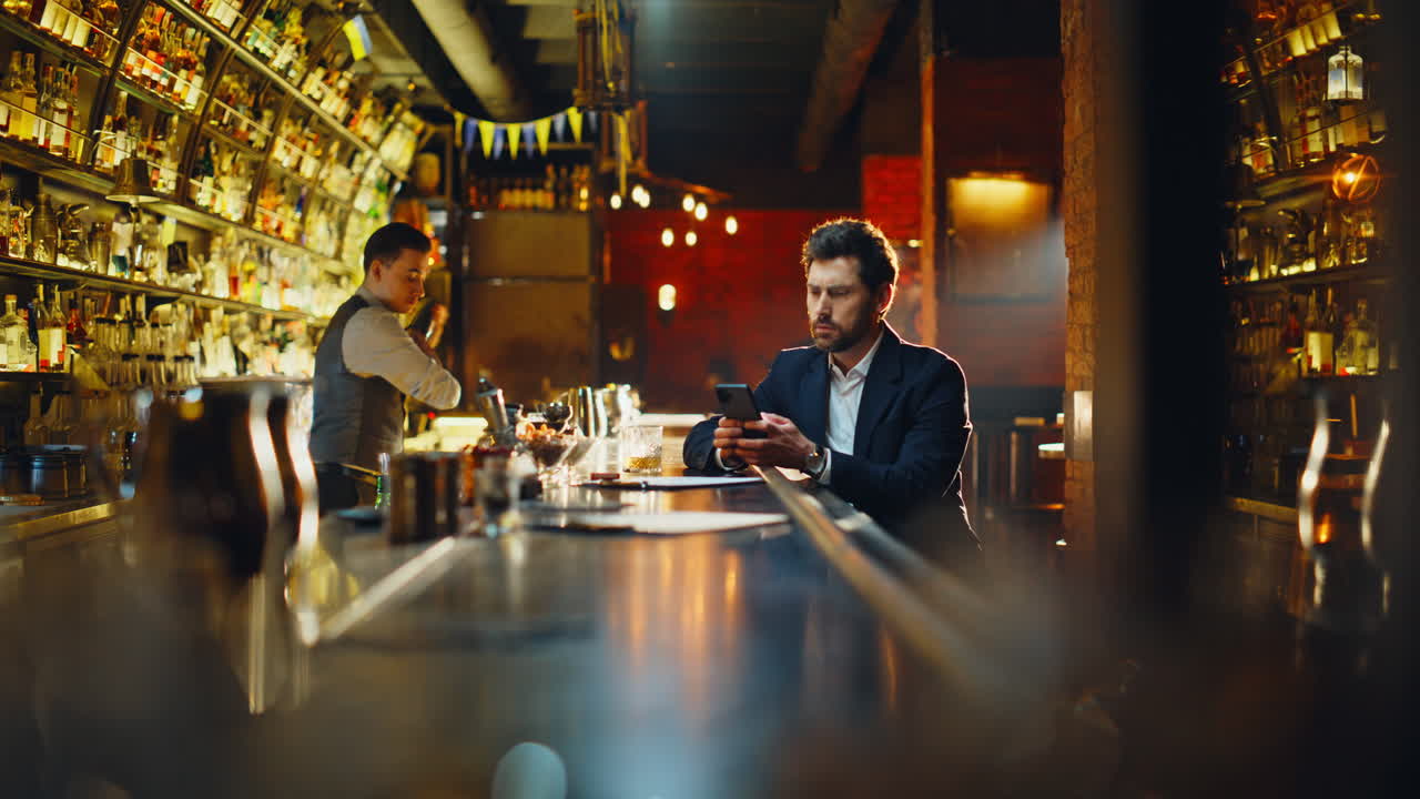 Bar guest checking time browsing internet on cellphone. Man waiting someone