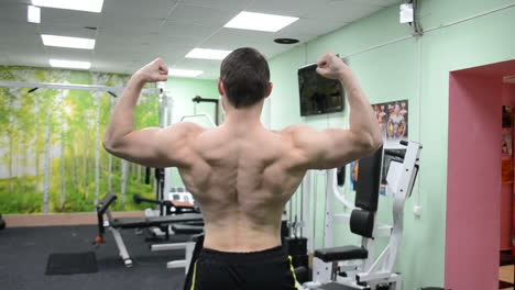 Bodybuilder-Mann-Spannt-Seine-Oberkörpermuskulatur-In-Einem-Fitnessstudio-An-Und-Präsentiert-Den-Aufbau-Einer-Körperlinie,-Ein-Trainings--Und-Fitnesskonzept