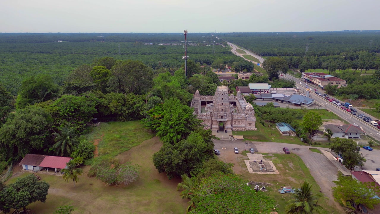 Sri Shakti Temple, a Hindu temple, viewed from an aerial perspective, standing amidst palm oil plantations and green nature. Amazing aerial view panorama overview drone