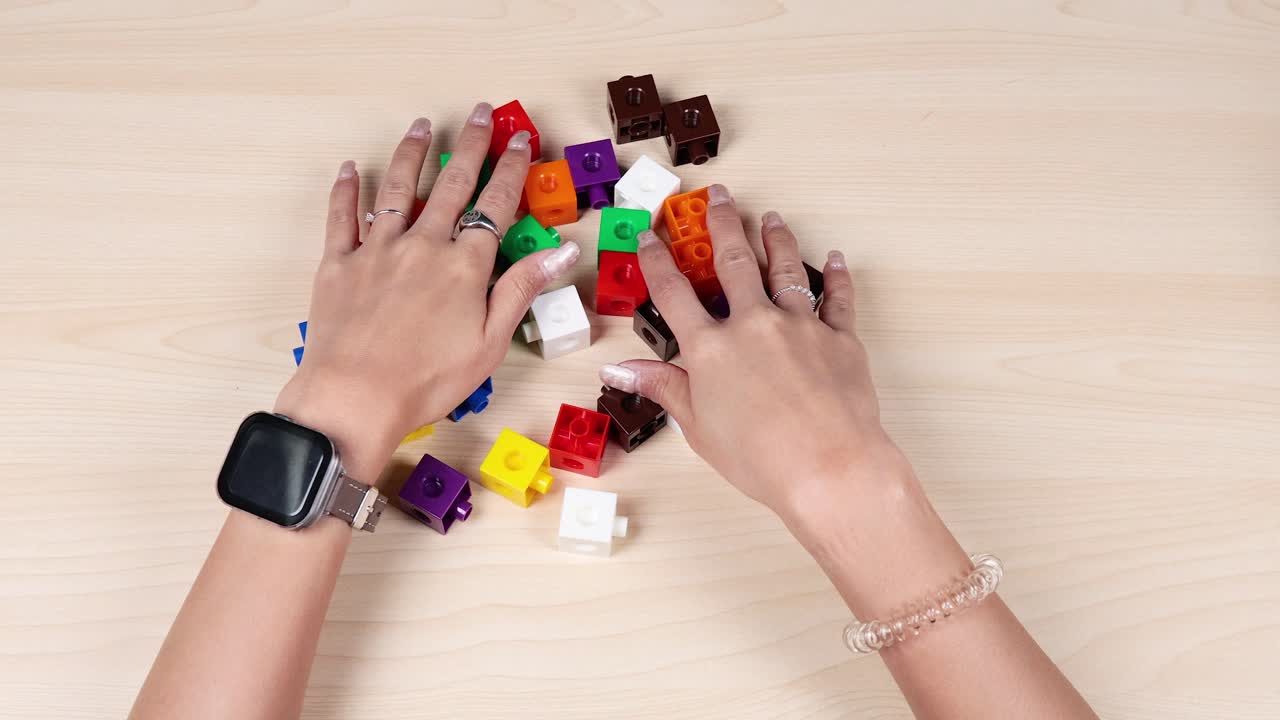 manos organizando cubos de colores en una mesa