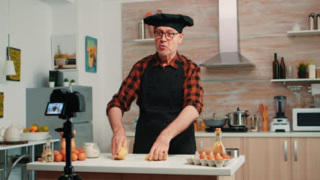 abuelo grabando video de comida en la cocina