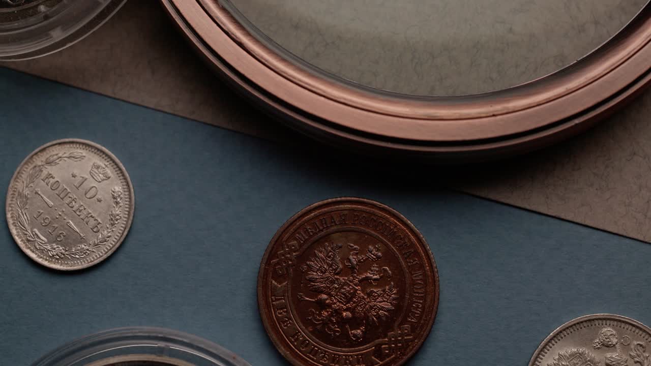 numismática, monedas de colección viejas y una lupa en la mesa.