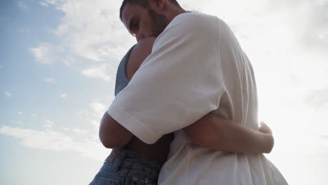 man and woman hugging on beach