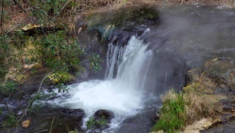 Flowing-hot-water-stream-river-with-cascades-from-sulphuric-hot-spring-in-Waimangu-Volcanic-Rift-Valley,-Rotorua,-New-Zealand-Aotearoa