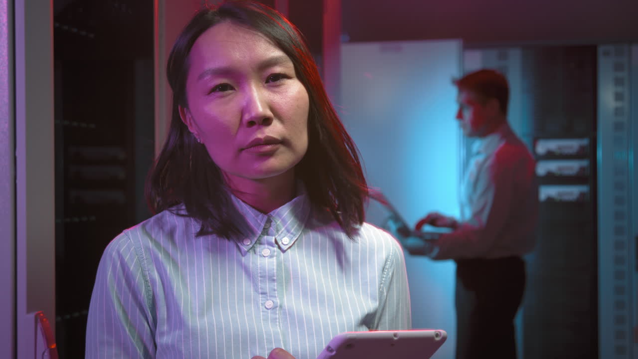 Asian Woman with Tablet Posing in Data Center
