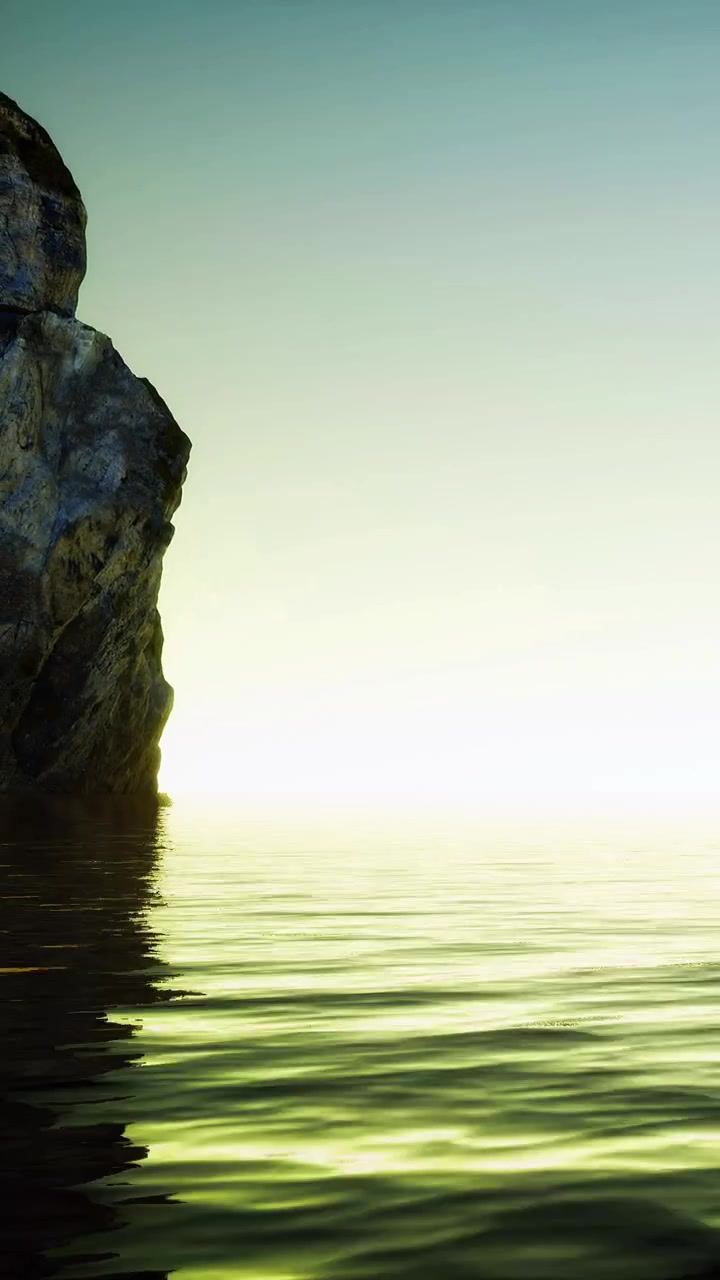 Sunrise at the rocky coast with calm water reflecting light from the sky