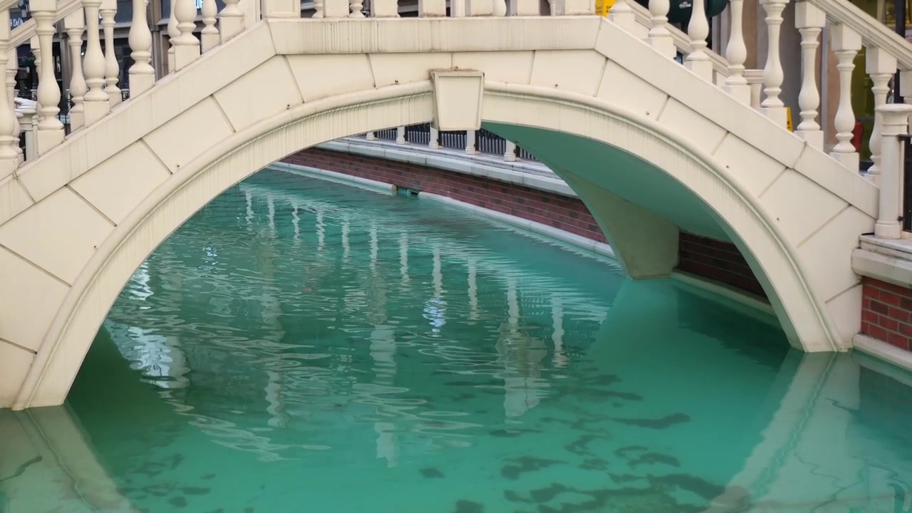 Puente de piedra blanco sobre agua turquesa de canal