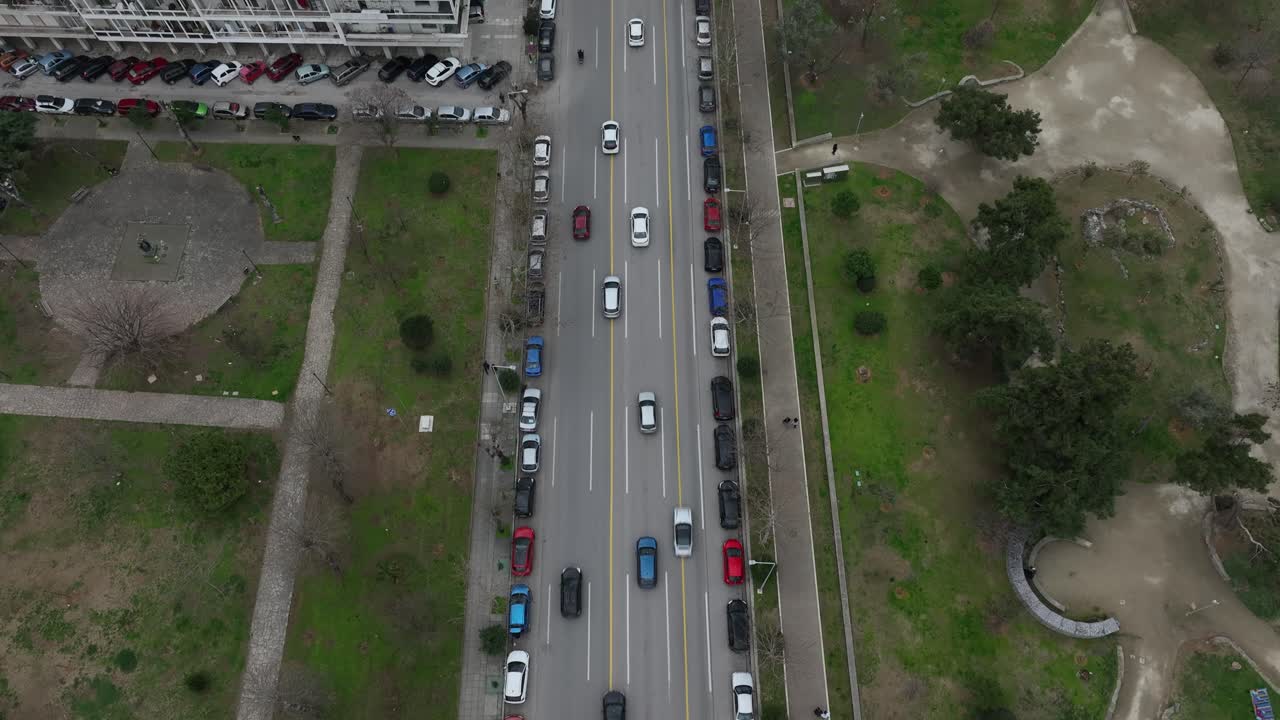 Thessaloniki downtown street with cars passing by and parked, aerial view. People commuting